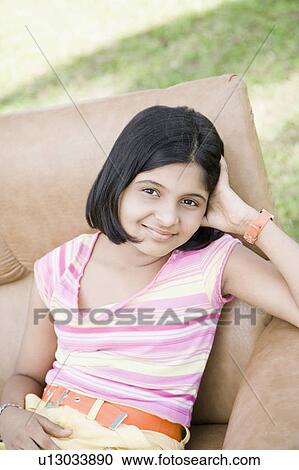 Portrait of a girl sitting in an armchair and smiling View Large Photo Image Stock Image - Portrait of a girl sitting in an armchair and smiling. Fotosearch