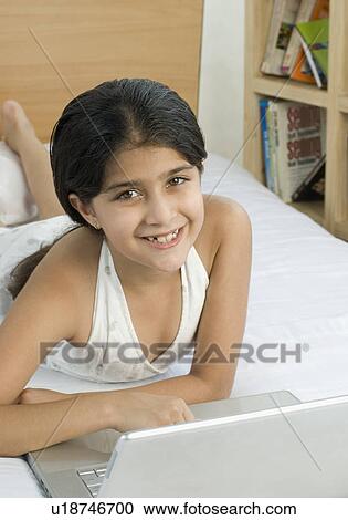 Portrait of a girl using a laptop and smiling View Large Photo Image Stock Image - Portrait of a girl using a laptop and smiling. Fotosearch