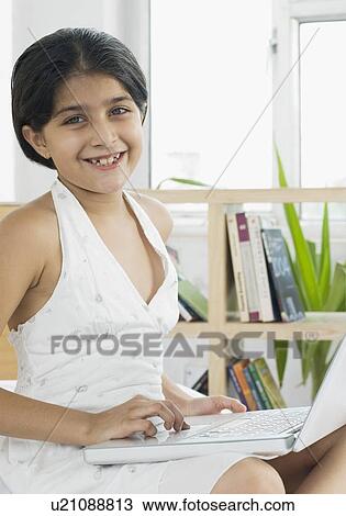 Portrait of a girl using a laptop and smiling View Large Photo Image Stock Image - Portrait of a girl using a laptop and smiling. Fotosearch