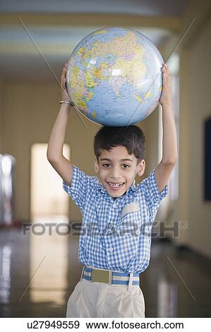 Stock Photo - Portrait of a schoolboy holding a globe above his head. Fotosearch