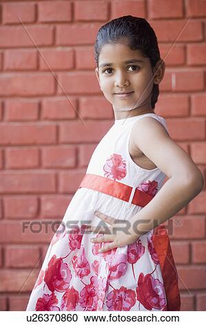 Portrait of a schoolgirl posing in front of a brick wall View Large Photo Image Stock Image - Portrait of a schoolgirl posing in front of a brick wall. Fotosearch