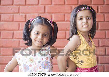 Portrait of two schoolgirls standing in front of a brick wall and smiling View Large Photo Image Stock Photo - Portrait of two schoolgirls standing in front of a brick wall and smiling. Fotosearch