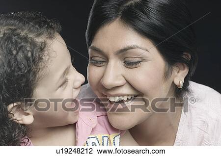 Close-up of a mid adult woman with her daughter smiling View Large Photo Image Stock Image - Close-up of a mid adult woman with her daughter smiling. Fotosearch