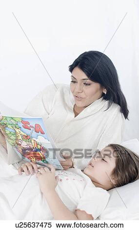 Girl reading a book with her mother View Large Photo Image Stock Photography - Girl reading a book with her mother. Fotosearch