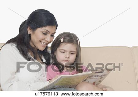 Mid adult woman and her daughter reading a book View Large Photo Image Stock Image - Mid adult woman and her daughter reading a book. Fotosearch