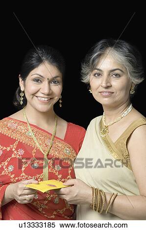Portrait of a mature woman giving a gift to her daughter View Large Photo Image Stock Photography - Portrait of a mature woman giving a gift to her daughter. Fotosearch