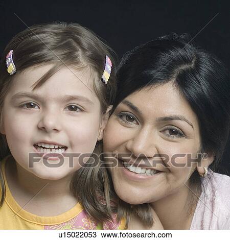 Portrait of a mid adult woman smiling with her daughter View Large Photo Image Stock Image - Portrait of a mid adult woman smiling with her daughter. Fotosearch