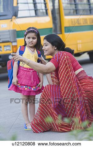 School teacher pointing forward with her student standing beside her View Large Photo Image Stock Photo - School teacher pointing forward with her student standing beside her. Fotosearch
