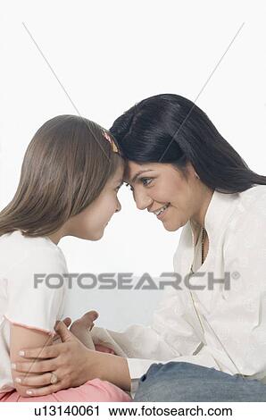 Side profile of a mid adult woman with her daughter playing and smiling View Large Photo Image Stock Image - Side profile of a mid adult woman with her daughter playing and smiling. Fotosearch