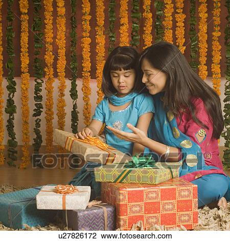 Young woman sitting with her daughter and holding diwali gifts View Large Photo Image Stock Image - Young woman sitting with her daughter and holding diwali gifts. Fotosearch