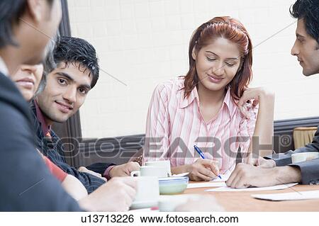 Stock Photograph - Business executives discussing in a conference room. Fotosearch
