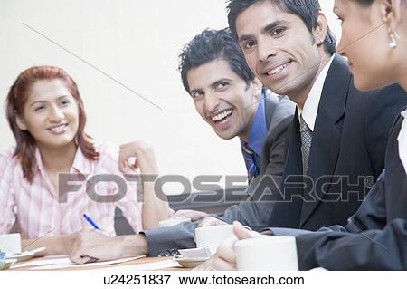 Business executives smiling in a conference room View Large Photo Image Stock Photo - Business executives smiling in a conference room. Fotosearch