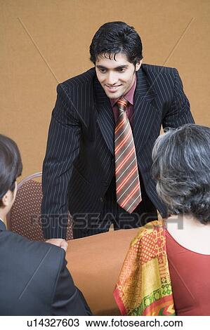 Stock Image - Businessman discussing with two business executives in a meeting. Fotosearch