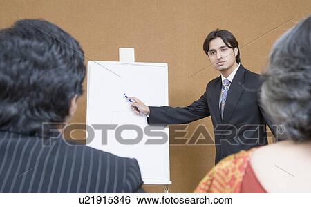 Stock Photograph - Businessman giving presentation in a meeting. Fotosearch