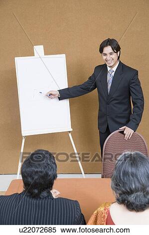 Stock Photography - Businessman giving presentation in a meeting . Fotosearch