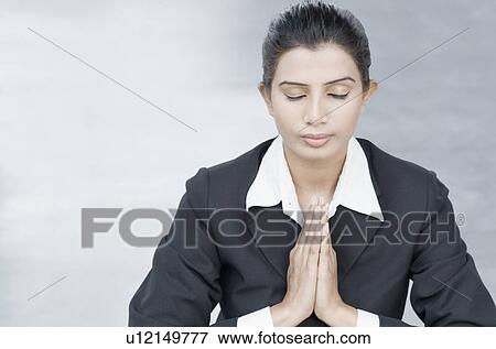 Close-up of a businesswoman meditating in prayer position View Large Photo Image Stock Photo - Close-up of a businesswoman meditating in prayer position. Fotosearch