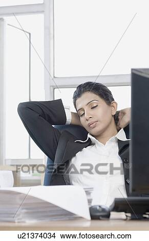 Close-up of a businesswoman sleeping in an office View Large Photo Image Picture - Close-up of a businesswoman sleeping in an office. Fotosearch