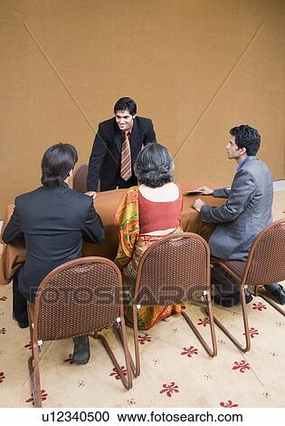 Four business executives in a business meeting View Large Photo Image Stock Image - Four business executives in a business meeting. Fotosearch