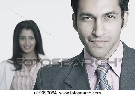 Portrait of a businessman with a businesswoman standing behind him View Large Photo Image Picture - Portrait of a businessman with a businesswoman standing behind him. Fotosearch