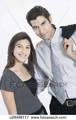 Stock Photo - Portrait of a young couple standing together and smiling. Fotosearch