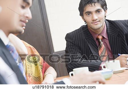 Stock Photo - Three business executives sitting in a meeting. Fotosearch