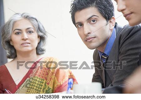 Stock Photo - Two businesswomen and a businessman in a conference room. Fotosearch