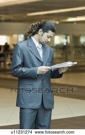 Businessman reading a newspaper View Large Photo Image Picture - Businessman reading a newspaper. Fotosearch