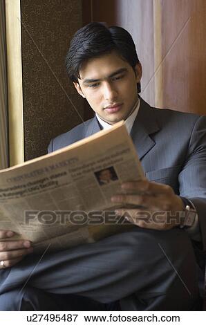 Businessman reading a newspaper View Large Photo Image Stock Photo - Businessman reading a newspaper. Fotosearch