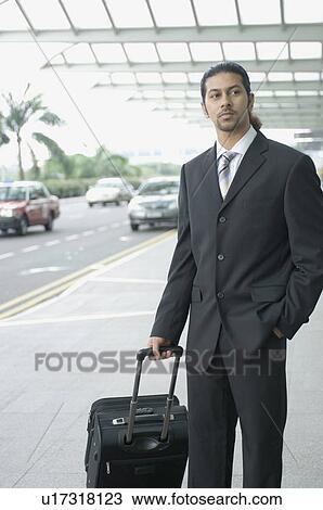 Businessman standing at an airport and waiting View Large Photo Image Stock Image - Businessman standing at an airport and waiting. Fotosearch
