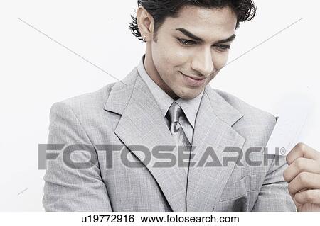 Stock Photograph - Close-up of a businessman holding a business card. Fotosearch
