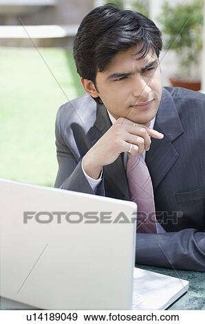 Stock Photo - Close-up of a businessman in front of a laptop. Fotosearch