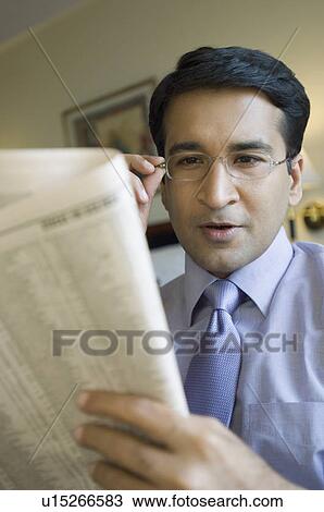 Close-up of a businessman reading a newspaper View Large Photo Image Stock Image - Close-up of a businessman reading a newspaper. Fotosearch