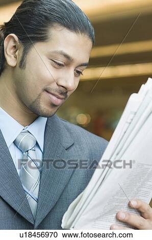 Close-up of a businessman reading a newspaper View Large Photo Image Stock Image - Close-up of a businessman reading a newspaper. Fotosearch