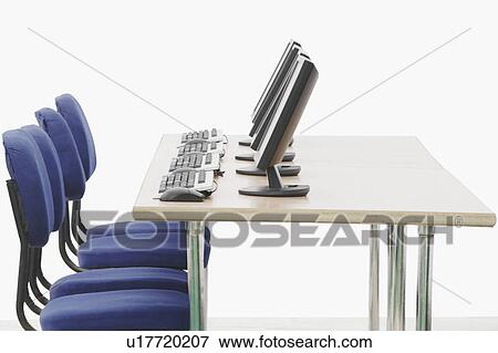 Stock Photo - Computer on a table in front of chairs. Fotosearch