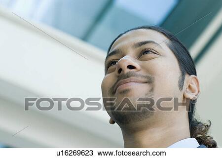 Low angle view of a businessman grinning View Large Photo Image Stock Image - Low angle view of a businessman grinning. Fotosearch
