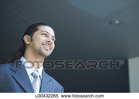 Low angle view of a businessman smiling at an airport View Large Photo Image Stock Photography - Low angle view of a businessman smiling at an airport. Fotosearch