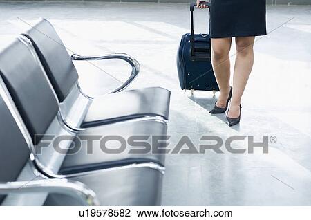 Low section view of a young woman carrying a luggage at an airport View Large Photo Image Stock Image - Low section view of a young woman carrying a luggage at an airport. Fotosearch