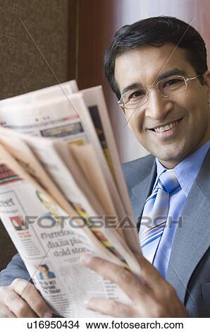 Portrait of a businessman holding a newspaper and smiling View Large Photo Image Picture - Portrait of a businessman holding a newspaper and smiling. Fotosearch