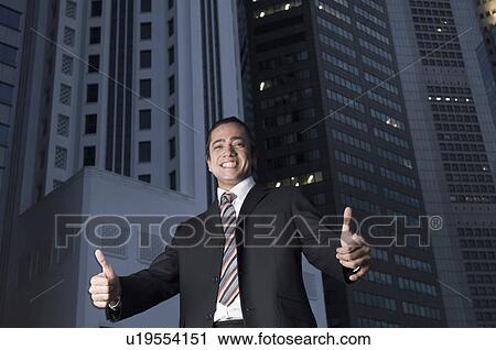 Portrait of a businessman making thumbs up signs and smiling, Singapore View Large Photo Image Stock Image - Portrait of a businessman making thumbs up signs and smiling, Singapore. Fotosearch