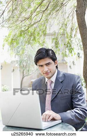 Stock Image - Portrait of a businessman using a laptop. Fotosearch