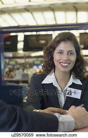 Portrait of an airline check-in attendant smiling View Large Photo Image Stock Photo - Portrait of an airline check-in attendant smiling. Fotosearch