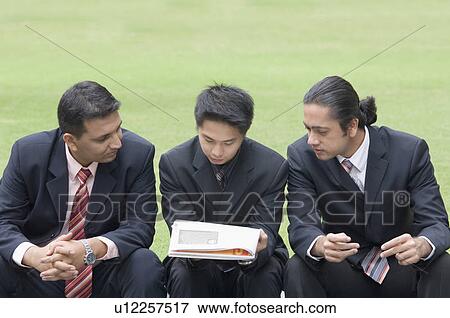 Stock Photo - Three businessmen reading a document. Fotosearch