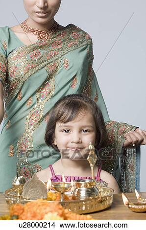 Picture - Close-up of a girl praying with her mother. Fotosearch