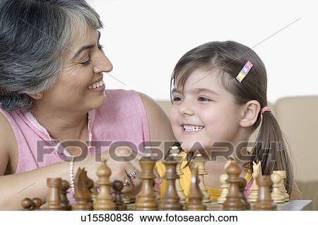 Close-up of a mature woman playing chess with her granddaughter and smiling View Large Photo Image Stock Photograph - Close-up of a mature woman playing chess with her granddaughter and smiling. Fotosearch