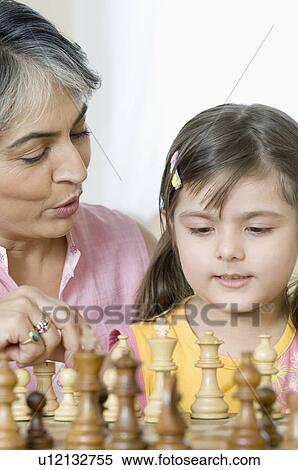 Close-up of a mature woman playing chess with her granddaughter View Large Photo Image Stock Photography - Close-up of a mature woman playing chess with her granddaughter. Fotosearch