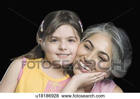 Close-up of a mature woman smiling with her granddaughter View Large Photo Image Stock Photo - Close-up of a mature woman smiling with her granddaughter. Fotosearch