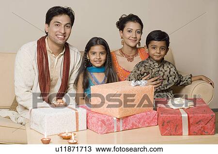 Close-up of gifts on a table in front of two generation family View Large Photo Image Stock Image - Close-up of gifts on a table in front of two generation family. Fotosearch