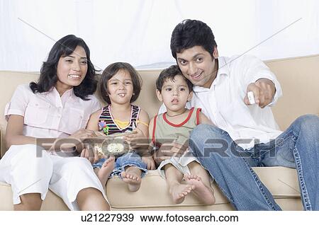 Couple sitting with their children on a couch View Large Photo Image Stock Photo - Couple sitting with their children on a couch. Fotosearch