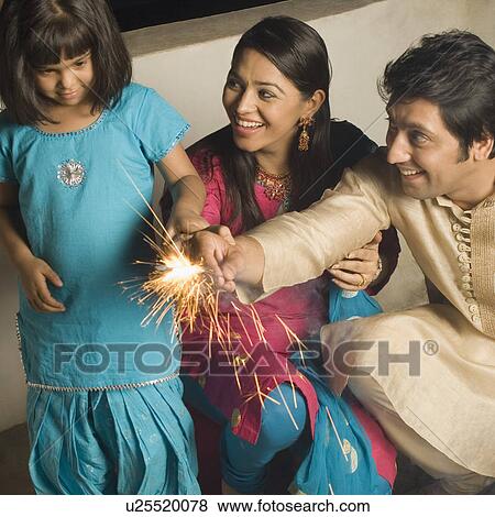 Girl with her parents burning firecrackers View Large Photo Image Stock Photo - Girl with her parents burning firecrackers. Fotosearch