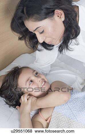 Stock Photo - High angle view of a young woman smiling with her daughter. Fotosearch